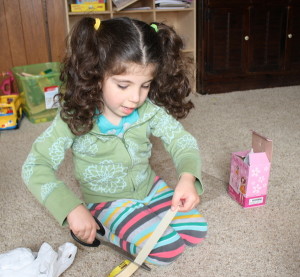 Lucy creating her contraption from an old box and tissue paper.
