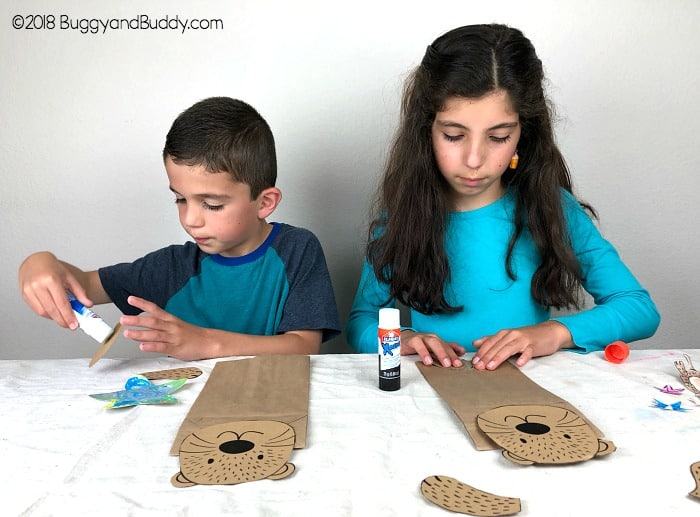 glue your sea otter pieces to the paper bag to make your puppet